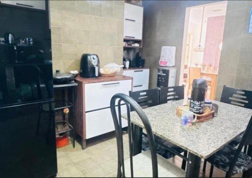 a kitchen with a table with chairs and a counter top at Casa com 3 quartos carnaval Olinda in Olinda