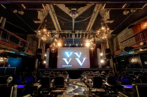 a stage with a large screen in a theatre at Backstage Boutique SPA Hotel in Zermatt