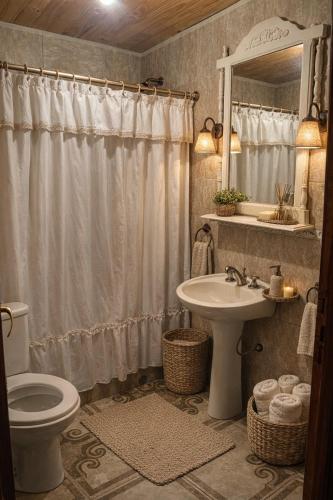 a bathroom with a toilet and a sink and a mirror at Cabañas Los Lapachos in Chicoana