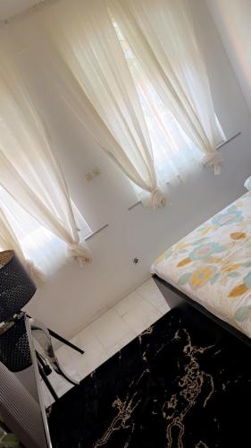 a bedroom with a bed and a window with curtains at Majorelle in Brussels