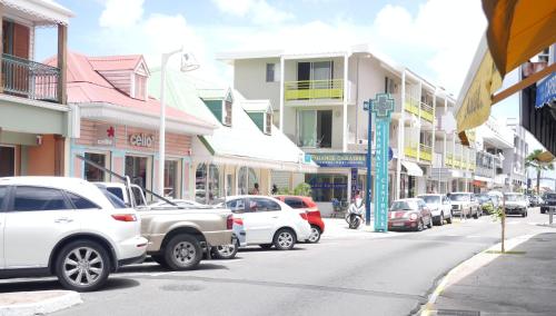 a city street with cars parked on the street at Studio Moderne, Centre Ville Marigot in Marigot
