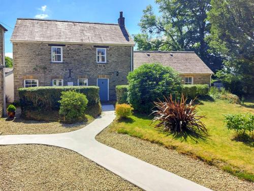 a stone house with a pathway leading to it at Tyn Y Coed in Bettws-Evan