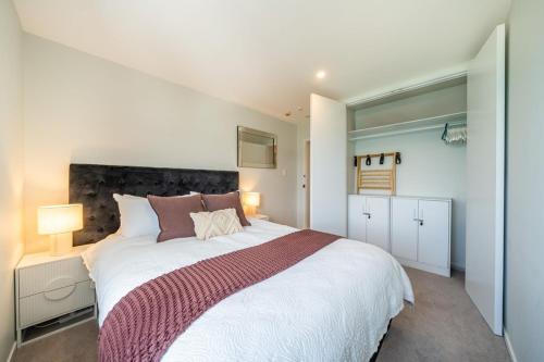 a bedroom with a large white bed in a room at Luxury Beachfront Apartment - Private Upper Suite in Wellington