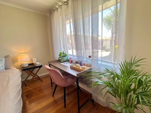 a room with a desk and a window with a bed at Oakleigh Haven in Oakleigh East