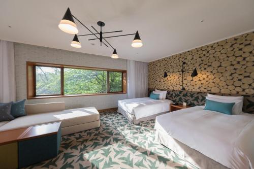 a hotel room with two beds and a couch at Karuizawa Prince Hotel East in Karuizawa