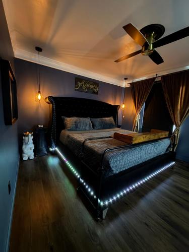 a bedroom with a bed with a ceiling fan and lights at Luxurious Getaway at Js Place in Charlotte