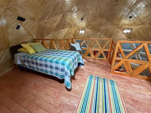 a bedroom with a bed in a wooden cabin at Cabaña Dalcahue Avenida Mocopulli in Dalcahue
