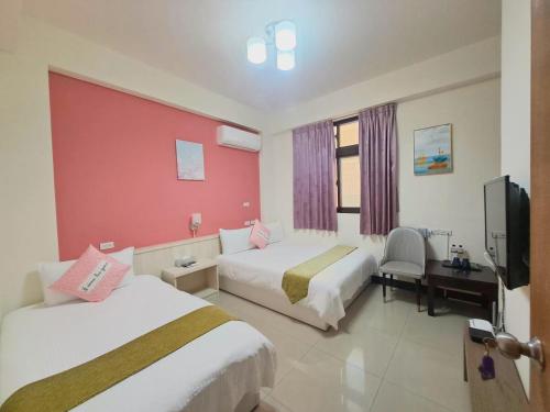a hotel room with two beds and a tv at Yang's B&B in Jinning