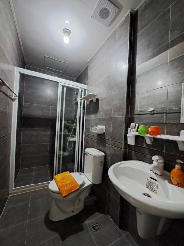 a bathroom with a shower and a toilet and a sink at Yang's B&B in Jinning