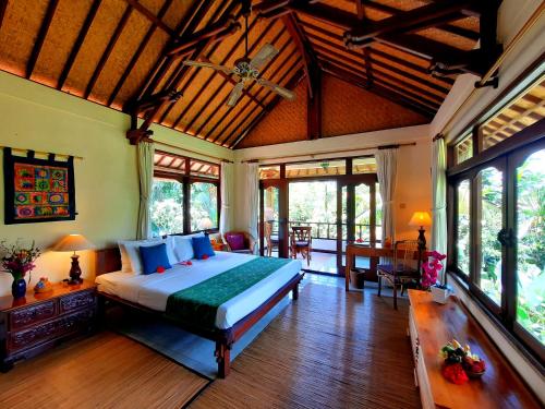 a bedroom with a large bed in a room at Alam Indah Ubud in Ubud