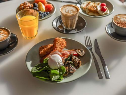 a table with plates of food and drinks on it at Peppers Salt Resort & Spa in Kingscliff