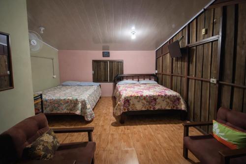 a room with two beds and a couch and a tv at Tropical Quiet Retreat in Venecia