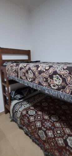 a bunk bed with a patterned blanket on it at La Guarida 3 in Concepción