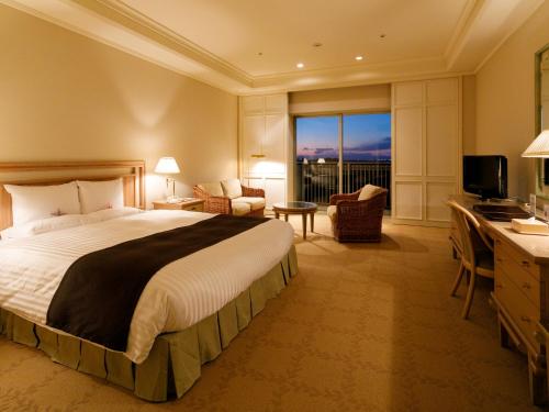 a hotel room with a large bed and a desk at Okura Akademia Park Hotel in Kisarazu