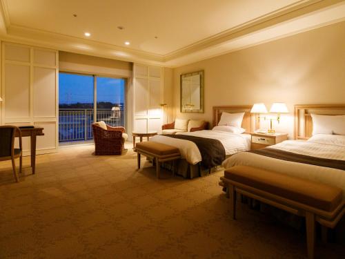 a hotel room with two beds and a balcony at Okura Akademia Park Hotel in Kisarazu
