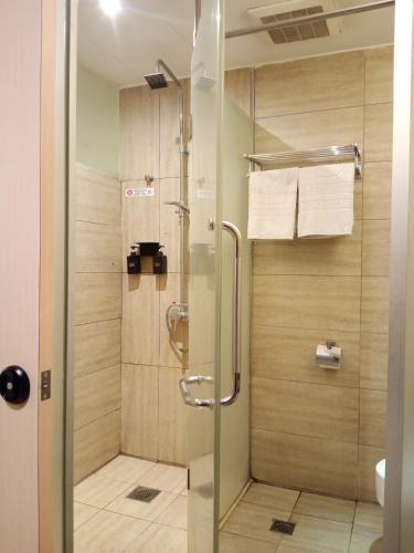 a shower with a glass door in a bathroom at Shervinton Executive Boutique Hotel in Tawau