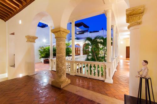 a woman is standing on the porch of a house at Hotel Quadrifolio in Cartagena de Indias