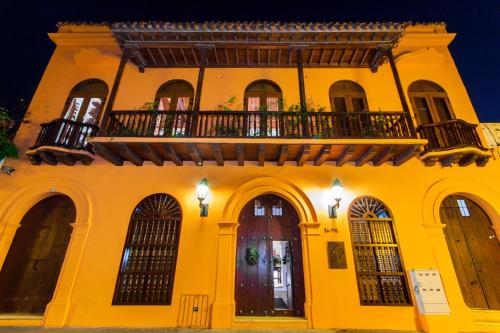 a yellow building with a balcony on top of it at Hotel Quadrifolio in Cartagena de Indias