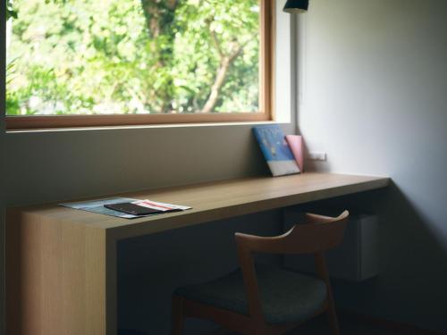 a desk with a chair in front of a window at SANU 2nd Home MON Amami Oshima in Tatsugo