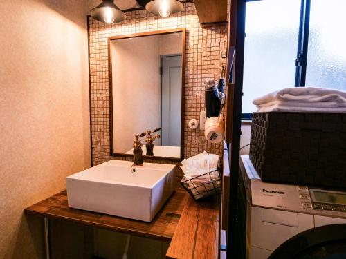 a bathroom with a white sink and a mirror at Villa228KASAMA in Kasama