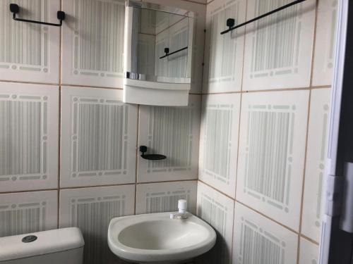a bathroom with a sink and a toilet and a mirror at Sobrado próximo ao mar em Salinas in Cidreira