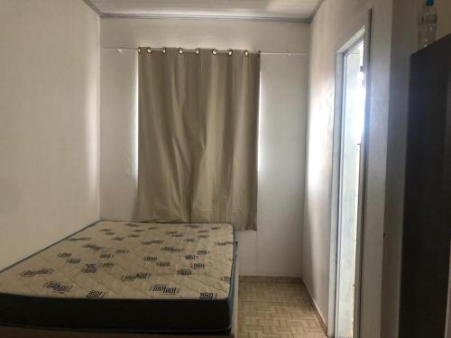 a bed in a room with a curtain at Sobrado próximo ao mar em Salinas in Cidreira