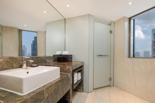 a bathroom with a sink and a mirror at Shanghai Qilu Hotel in Shanghai