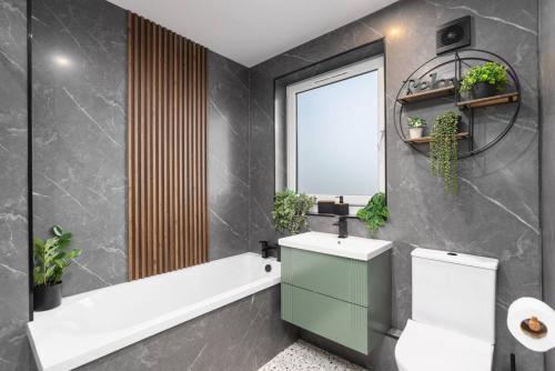 a bathroom with a sink and a toilet and a window at Paradykes House in Loanhead