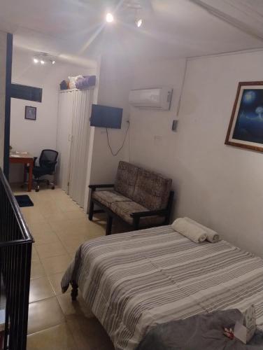 a bedroom with a bed and a couch and a chair at Bungalow Turrent, a 5 minutos de Playa Mocambo in Veracruz