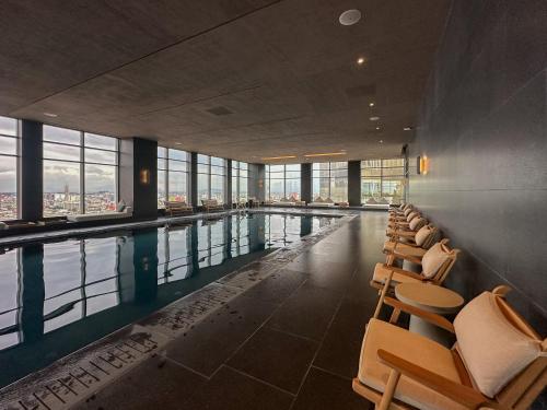 a swimming pool with chairs in a building at Luxury Apartment on Reforma in Mexico City