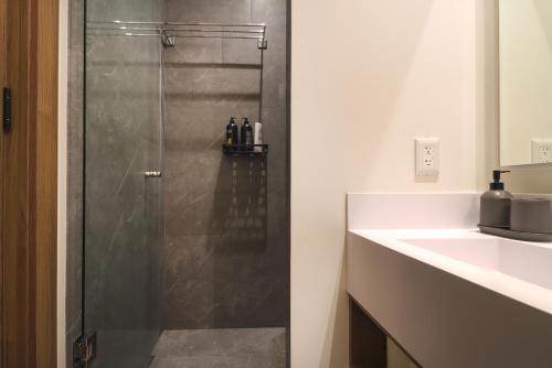 a shower with a glass door next to a sink at Luxury Apartment on Reforma in Mexico City