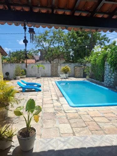 a swimming pool in a yard with a patio at Kitnetilha in Itamaracá