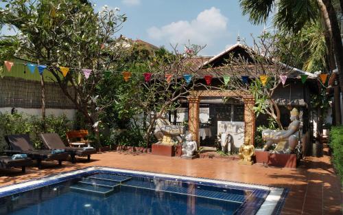 a swimming pool in front of a house at Harmony Indochine d'Angkor in Siem Reap