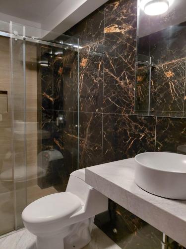 a bathroom with a white toilet and a sink at Matrix Alojamiento in Punta Negra