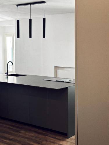 a kitchen with a black counter top and some lights at Paponena Holidays in Riva del Garda