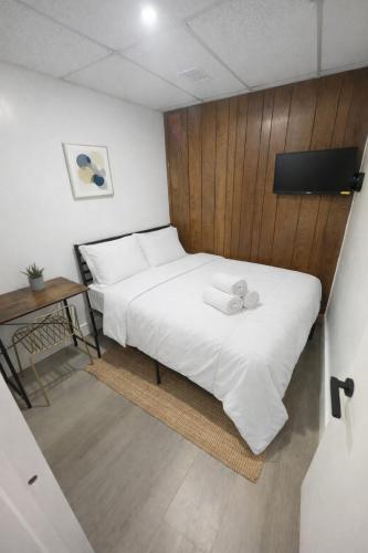 a bedroom with a white bed and a wooden wall at Santorini Hollywood in Hollywood