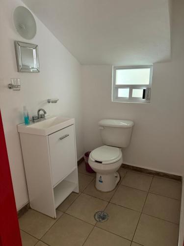 a bathroom with a toilet and a sink and a window at Casa amplia, cómoda y céntrica in Apizaco