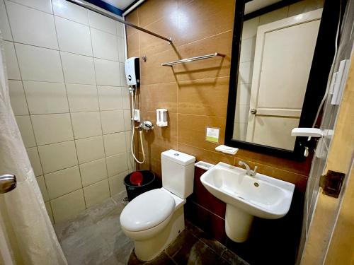 a bathroom with a toilet and a sink at D'Goldwin Lodge in Coron