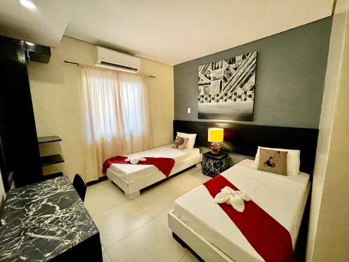 a hotel room with two beds in a room at D'Goldwin Lodge in Coron