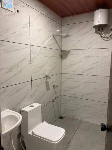 a bathroom with a toilet and a glass shower at Florence Stays Munnar in Munnar