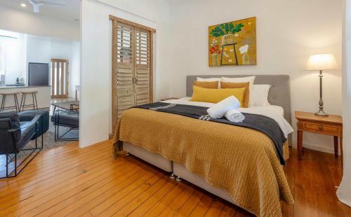 a bedroom with a large bed with yellow pillows at Luxury Couples Stay Bangalow l Nova Escapes in Bangalow