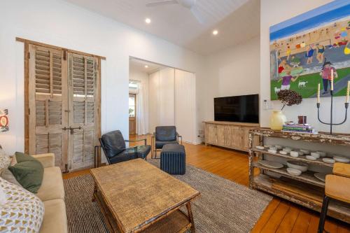 a living room with a couch and a tv at Luxury Couples Stay Bangalow l Nova Escapes in Bangalow