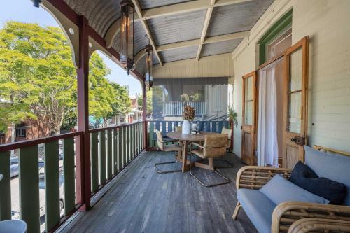 a porch with a table and chairs on it at Luxury Couples Stay Bangalow l Nova Escapes in Bangalow