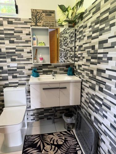 a bathroom with a sink and a toilet at Vaihi's Garden climatisé, vue sur mer - Huahine in HUH