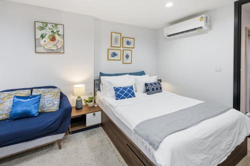 a bedroom with a bed and a couch in it at Luxury Resort Style 1 Bedroom Studio near Central in Phuket