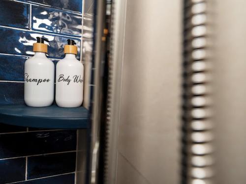 two white bottles sitting on a shelf in a bathroom at Shadyside 4B in Tân Thành (1)