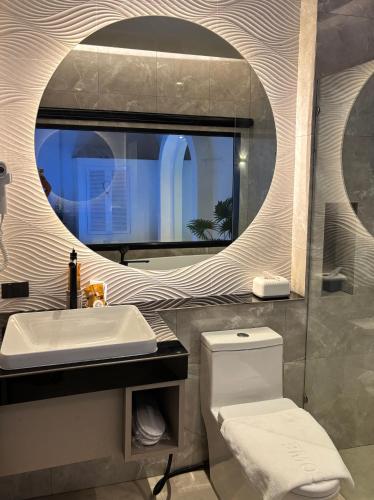 a bathroom with a sink and a toilet and a mirror at Mermayda pool villa hatyai -เมอเมดา in Hat Yai