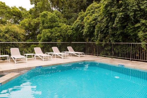 a swimming pool with chairs and a fence at Number One in Hastings Street in Noosa Heads