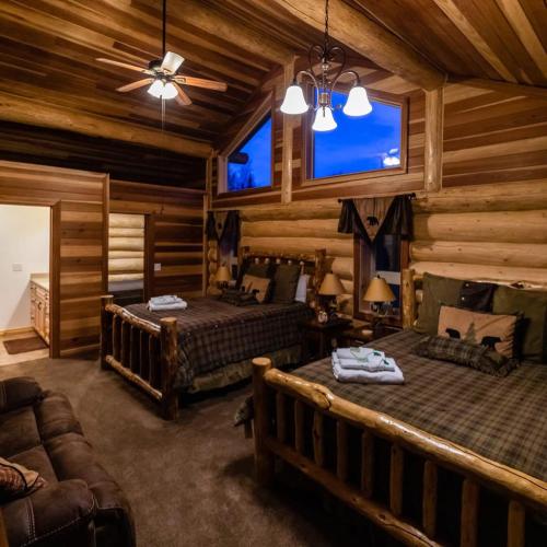 a log cabin bedroom with two beds and a couch at Alaska Knotty Pine Whole Building in Palmer