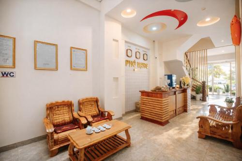 a room with chairs and a table and a desk at Phú Vang Hotel Pleiku in Pleiku